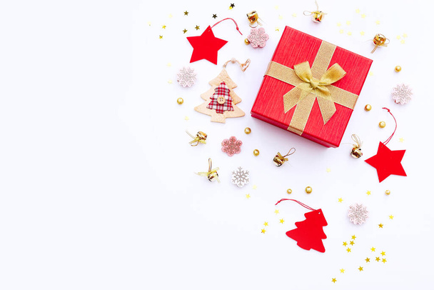 Σύνθεση Χριστουγέννων και Πρωτοχρονιάς με κενό χώρο για κείμενο. Χριστουγεννιάτικο δώρο, κόκκινη και χρυσή διακόσμηση σε λευκό φόντο. Επίπεδο lay, πάνω όψη, αντιγραφή χώρου - Φωτογραφία, εικόνα