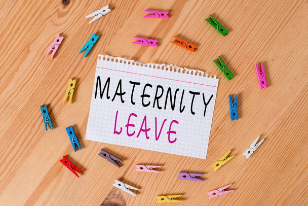 Conceptual hand writing showing Maternity Leave. Business photo showcasing a leave of absence for an expectant or a new mother Colored crumpled papers wooden floor background clothespin. - Photo, Image