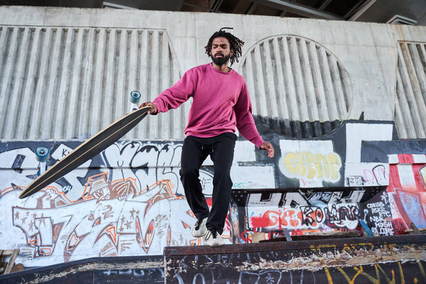 Skateboarder doing a trick in a skate park - Fotografie, Obrázek