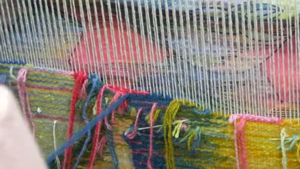 Bordado de carpete artesanal. As mãos das mulheres criam um padrão usando fios multicoloridos. Martelo para quors de bordado, fios de recheio. Vista de perto - Filmagem, Vídeo