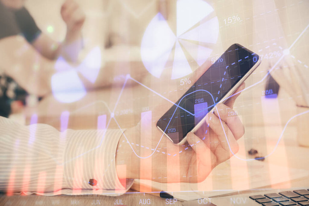 Double exposure of man's hands holding and using a digital device and forex graph drawing. Financial market concept. - Foto, Imagen