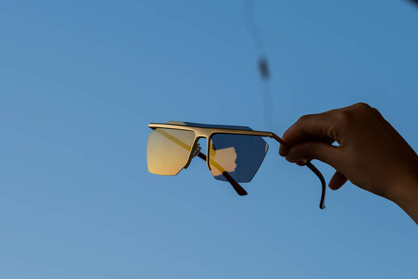 Futuristische zonnebril met grote lenzen met de hand close-up. - Foto, afbeelding
