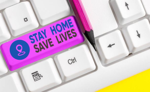 Schrijfbriefje met Stay Home Save Lives. Zakelijke foto showcasing vermindert het aantal geïnfecteerde patiënten door niet het huis te verlaten Gekleurde toetsenbord sleutel met accessoires geregeld op lege kopieerruimte. - Foto, afbeelding