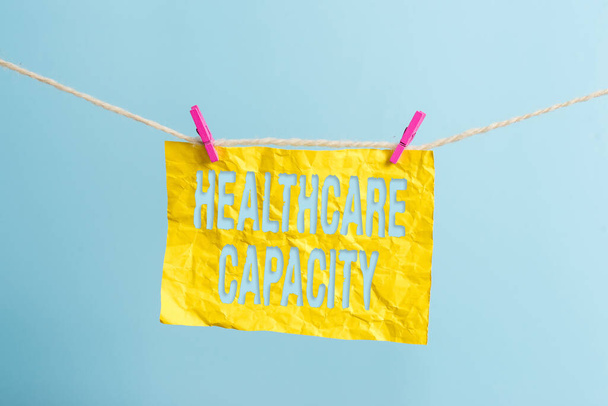 Word writing text Healthcare Capacity. Business concept for maximum amount of patients provided with the right medical service Clothesline clothespin rectangle shaped paper reminder white wood desk. - Foto, imagen