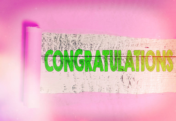 Text sign showing Congratulations. Conceptual photo a congratulatory expression usually used in plural form Rolled ripped torn cardboard placed above a wooden classic table backdrop. - Photo, Image