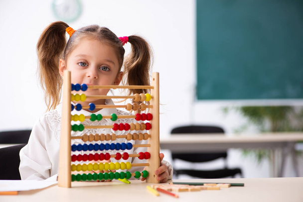 Klein meisje met abacus in de klas - Foto, afbeelding