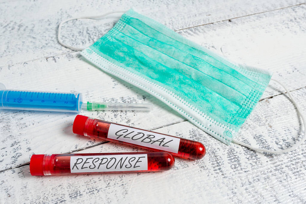 Text sign showing Global Response. Conceptual photo indicates the behaviour of material away from impact point Extracted blood sample vial with medical accessories ready for examination. - Photo, Image