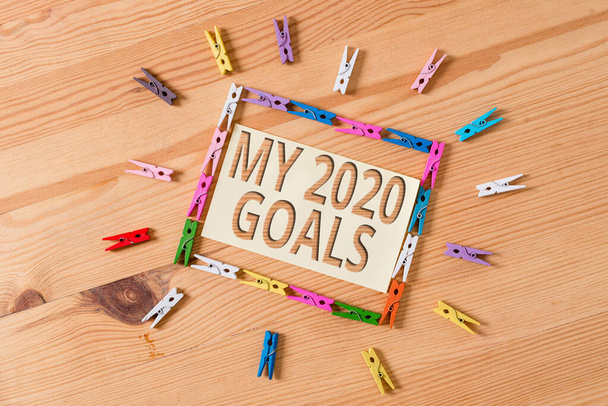 Tekst schrijven My 2020 Goals. Zakelijk concept voor het opzetten van een individuele doelen of plannen voor het lopende jaar Kleurwaspinpapier lege herinnering houten vloer achtergrond kantoor. - Foto, afbeelding