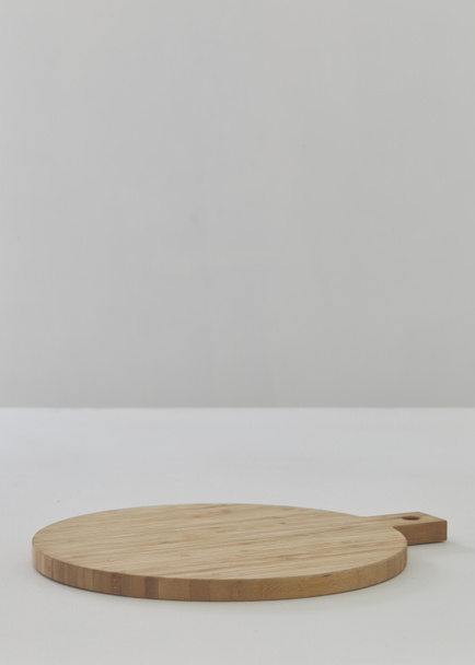 Une planche à découper ronde vide sur une table en bois blanc close up - Photo, image