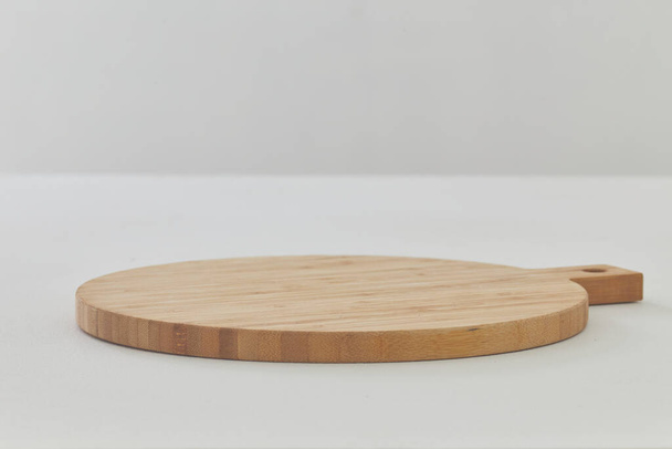 Une planche à découper ronde vide sur une table en bois blanc close up - Photo, image