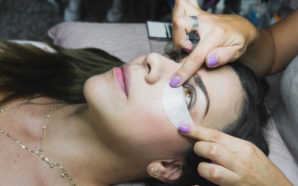 Honey colored eye woman getting ready for eyelash extension treatment - Фото, изображение