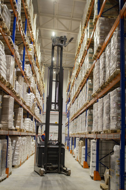 Loader in warehouses. Stacks of boxes in an industrial warehouse. - Photo, Image