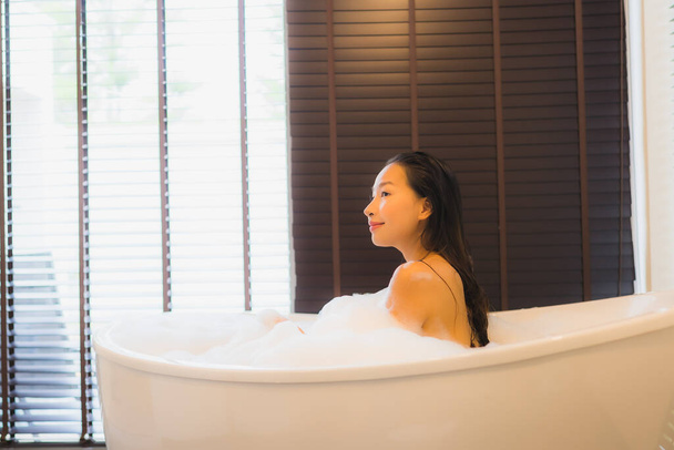 Porträt schöne junge asiatische Frau glücklich lächeln entspannen nehmen Sie ein Bad in der Badewanne des Badezimmers Innenraum - Foto, Bild