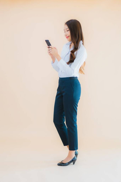 Portrait beautiful young business asian woman with smart mobile phone and coffee cup - Foto, Imagen