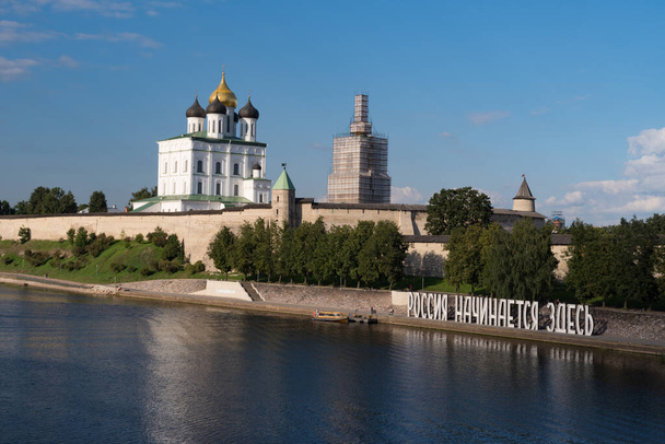 Bank van de rivier de Velikaya. Installatie "Rusland begint hier". Pskov Kremlin in de ochtend. Drie-eenheid kathedraal, Pskov, Rusland - Foto, afbeelding