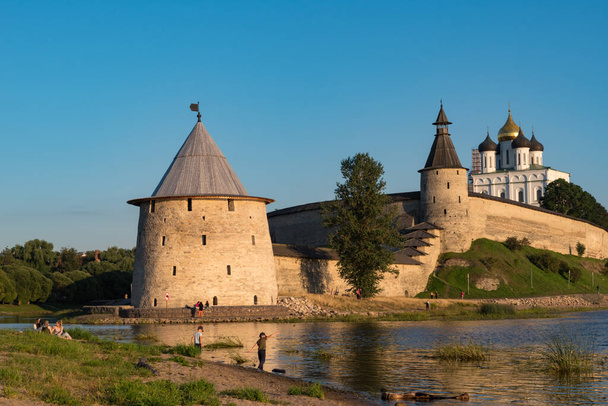 ロシアのプスコフ: 2020年8月21日:プスコフ・クレムリン川プスコヴァ・クリークからの眺め。背景にある塔、壁、トリニティ大聖堂. - 写真・画像
