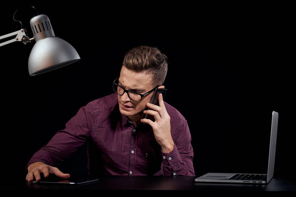 Άντρας διαχειριστής σε εσωτερικούς χώρους σκούρο φόντο επικοινωνία κόκκινο πουκάμισο μοντέλο γυαλιά νέες τεχνολογίες χρηματοδότηση των επιχειρήσεων - Φωτογραφία, εικόνα