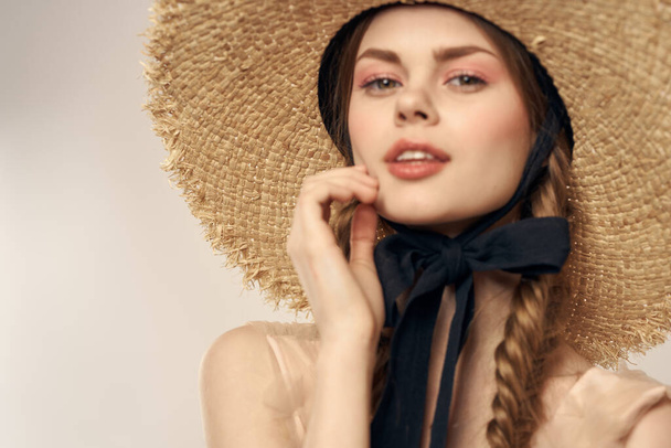 cute girl in straw hat with black ribbon and dress on beige background cropped view - Valokuva, kuva