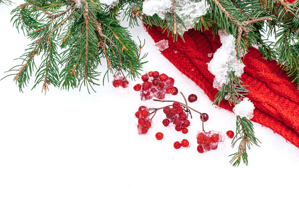 Frame made of red scarf, viburnum berries and fir branches on white snow.Christmas, winter, new year concept. Copy space for text - Photo, image