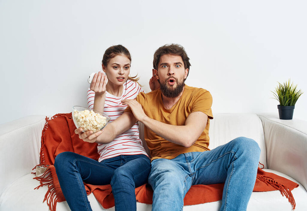 barátok férfi és nő popcorn egy tányéron beltéri kanapé belső - Fotó, kép