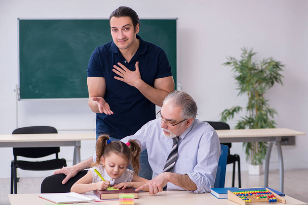 Νεαρός γονιός, ηλικιωμένος δάσκαλος και μικρό κορίτσι στην τάξη - Φωτογραφία, εικόνα