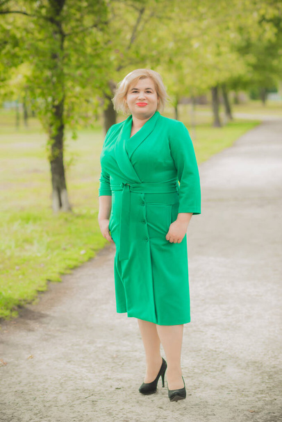 Portrait of American plus size businesswoman in green dress, citizen lifestyle, concept of women's life - Фото, изображение