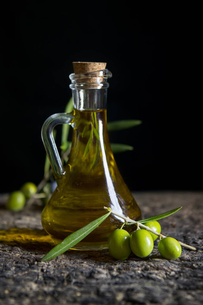 olio d'oliva e olive fresche sulla vecchia tavola - Foto, immagini