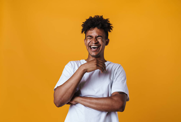 Image of cheerful african american guy laughing on camera isolated over yellow wall - Fotografie, Obrázek