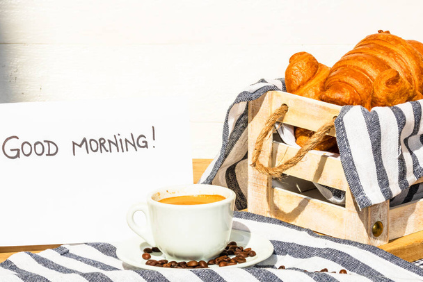 filiżanka kawy i masło świeże francuskie rogaliki na drewnianej skrzyni - Zdjęcie, obraz