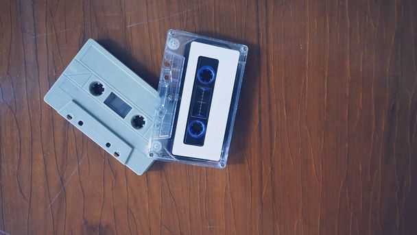 Lähikuva kuvia kasetti nauha retro puu pöytä. edustavat nostalgia tuulella tai hetki 80- tai 90-luvulla, että suurin osa äänimusiikkia tai kappaleita kirjataan kompakti ja kätevä laite tekniikka. - Valokuva, kuva