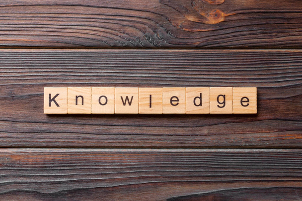 Palabra de conocimiento escrita en bloque de madera. Texto de conocimiento sobre mesa de cemento para su diseño, concepto. - Foto, imagen