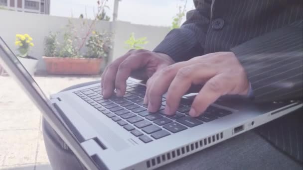 Επιχειρηματίας δακτυλογραφεί σε πληκτρολόγιο φορητού υπολογιστή φορώντας μπλέιζερ - Πλάνα, βίντεο