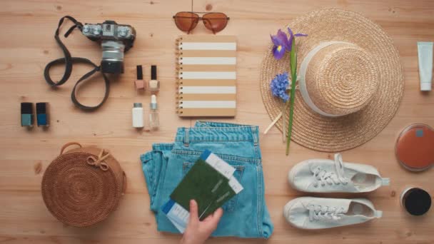 Horizontal de cima flat lay shot de objetos de viagem para bagagem, incluindo roupas, cosméticos e passaportes internacionais com bilhetes - Filmagem, Vídeo