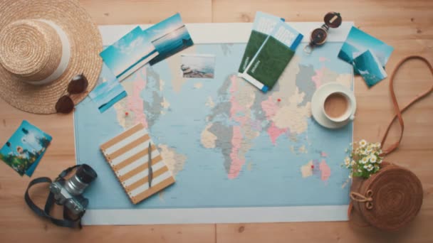 Horizontal stab from above conceptual flat lay footage of flying paper airplane with world map and travel objects in background - Footage, Video