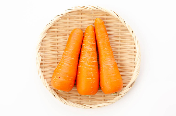 fresh Carrot on bamboo sieve on white background - Photo, Image
