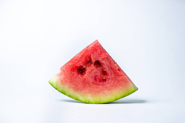Wassermelone auf weißem Hintergrund. Schneiden Sie eine Scheibe Wassermelone ab. Rote reife Wassermelone - Foto, Bild