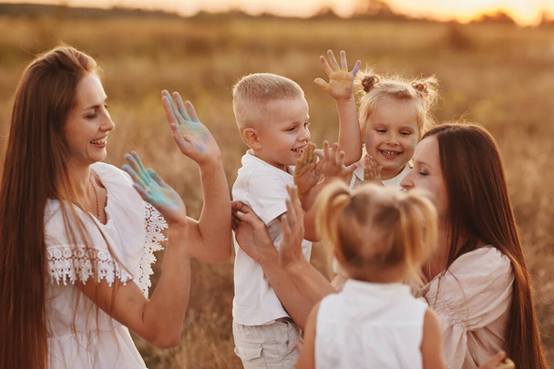 夏に子供たちと屋外で遊んでいる幸せな若いお母さん。幸せな家族の時間を一緒にコンセプト。選択的焦点. - 写真・画像