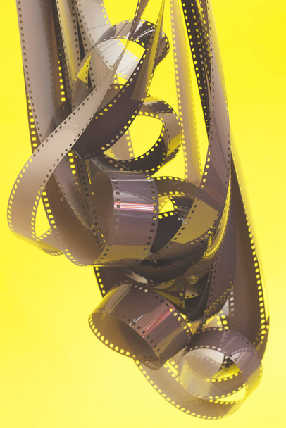 Отрицательная фотопленка на жёлтом фоне. 35-мм негативная пленка. - Фото, изображение