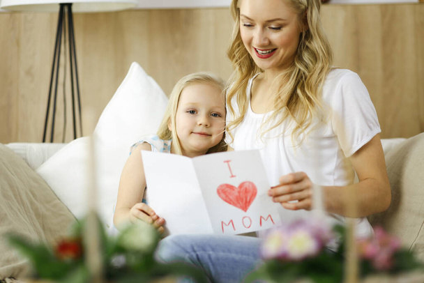 Happy mother day. Child daughter congratulates mom and gives her postcard with heart drawing. Family and childhood concepts - Fotoğraf, Görsel