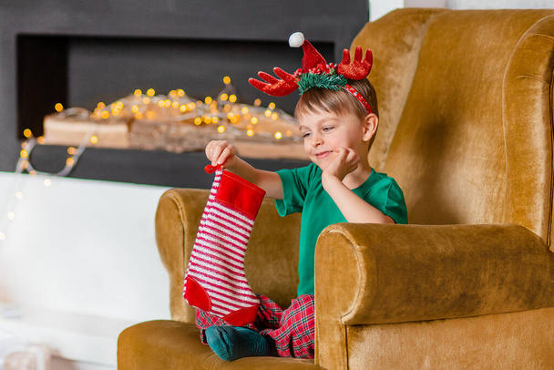 Cute boy waiting for a gift from Santa Claus, near the Christmas tree. Happy childhood, time to make wishes come true. Merry Christmas. - Zdjęcie, obraz