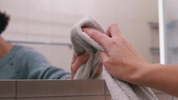 Γυναικείο χέρι πλένει καθρέφτη. Αντανάκλαση στον καθρέφτη μιας γυναικείας σιλουέτας - Πλάνα, βίντεο