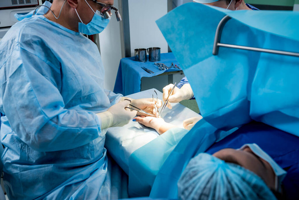 Chirurghi in sala operatoria che cercano di salvare la mano dei pazienti. - Foto, immagini
