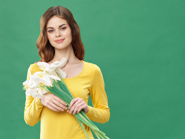 Woman with a bouquet of flowers in a yellow dress gift holiday womens day  - 写真・画像