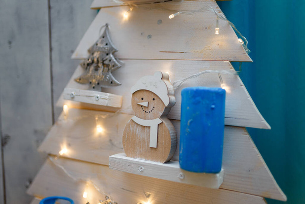 Merry Christmas interior decorative wooden firtree with toys, blue candle and garland lights - Φωτογραφία, εικόνα