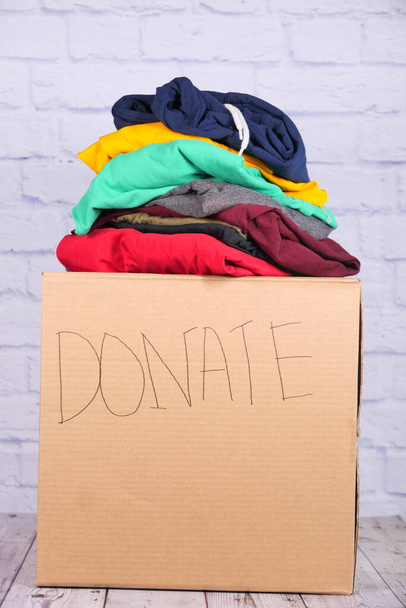 Donation box with donation clothes on a wooden table . - Photo, Image