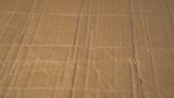 Brown crumpled cardboard texture. Crumpled shabby background. Packaging old material. Slow rotation - Footage, Video