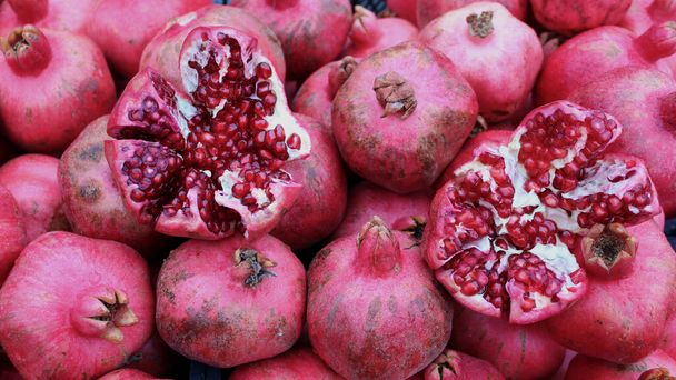 Juicy and ripe pomegranate. Ruby natural pomegranate fruit. Pomegranate slices and pomegranate fruit seeds.  - Fotó, kép