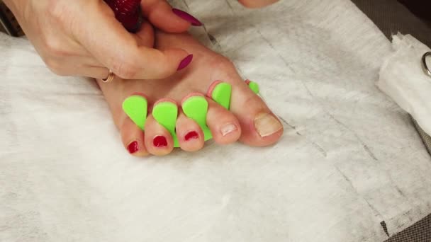Gros plan de pieds féminins peignant vernis à ongles rouge, pédicure auto-faite à la maison. - Séquence, vidéo