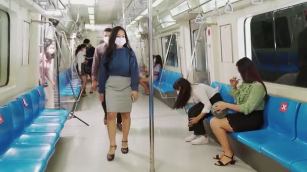 Een menigte mensen met gezichtsmaskers op een drukke openbare metro. - Video
