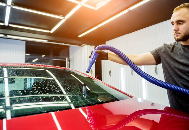 Service medewerker maakt automatisch drogen van de auto na het wassen. - Foto, afbeelding